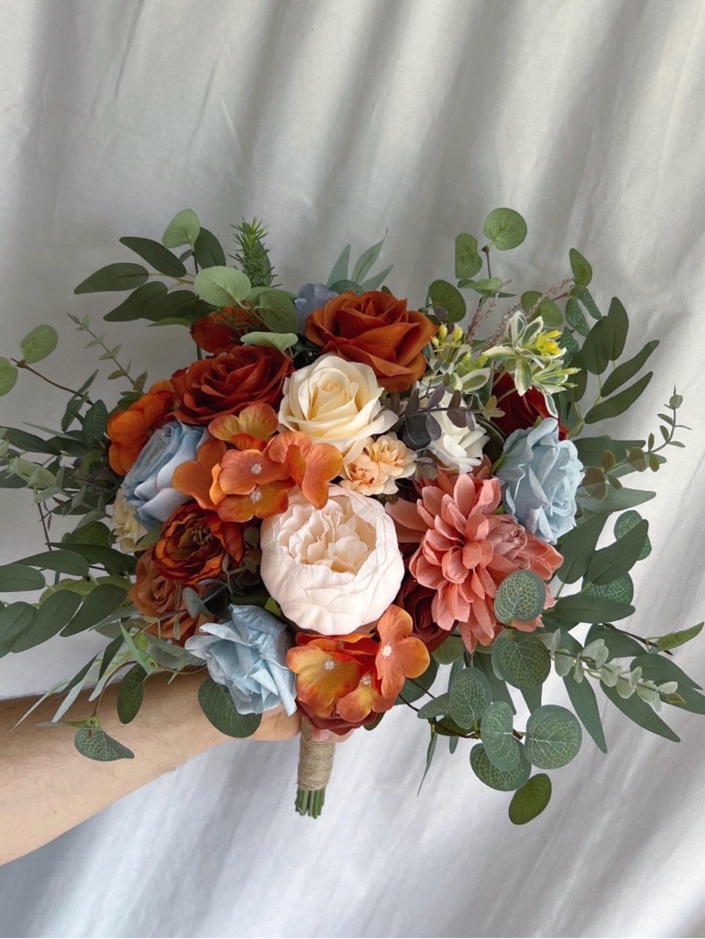 Faux bridal bouquets with rust orange, dusty blue, & eucalyptus.